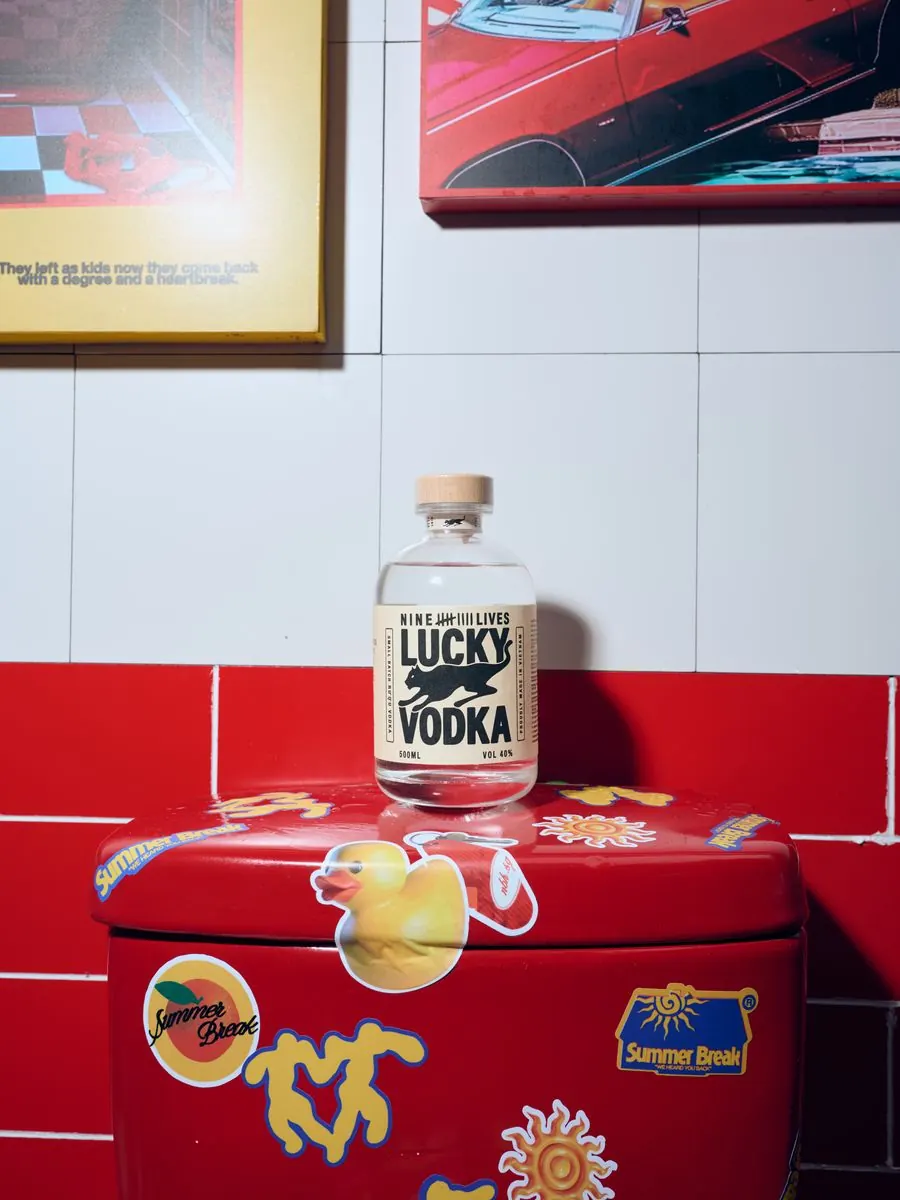 A bottle of Lucky Vodka on a red sticker-covered stand
