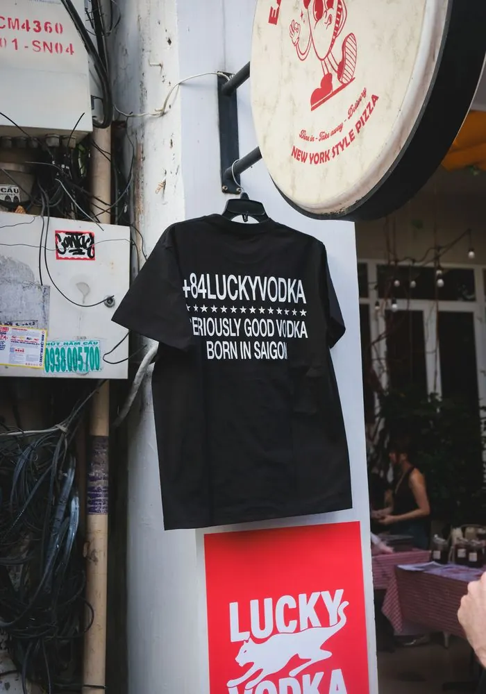 A +84 Lucky Vodka tee hanging outside a bar